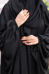 Close-up zoom of black kaftan abaya showing premium imported fabric texture and fine finishing.