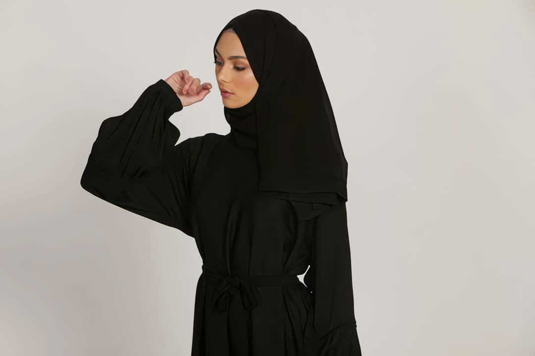 Close-up of simple elasticated cuffs on black abaya dress, soft fabric detail