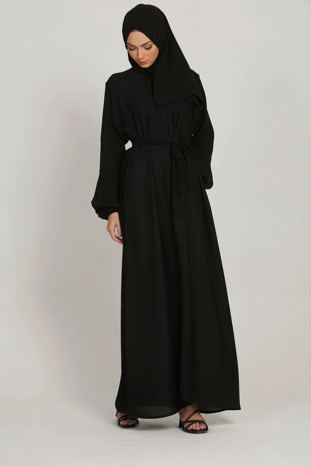 Detailed fabric texture of black abaya dress, smooth lightweight material with fine stitching