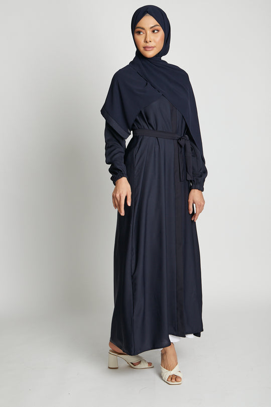 Stylish front full view of deep navy open kimono abaya layered with white slip dress, abaya with elastic cuffs for women in Pakistan