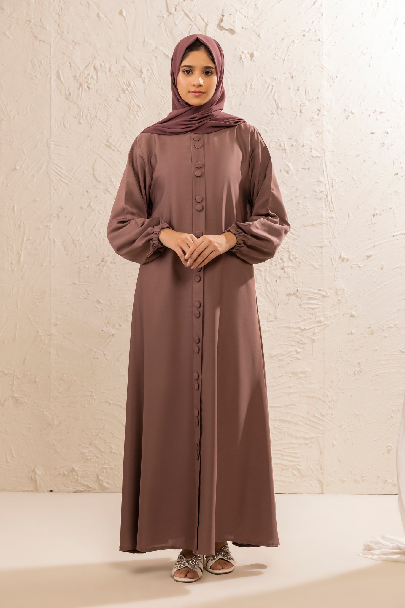 Front full view of simple and elegant rose taupe abaya with button-down front and cuffed sleeves, modest fashion abaya