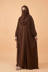 Woman wearing a brown abaya on a beige background