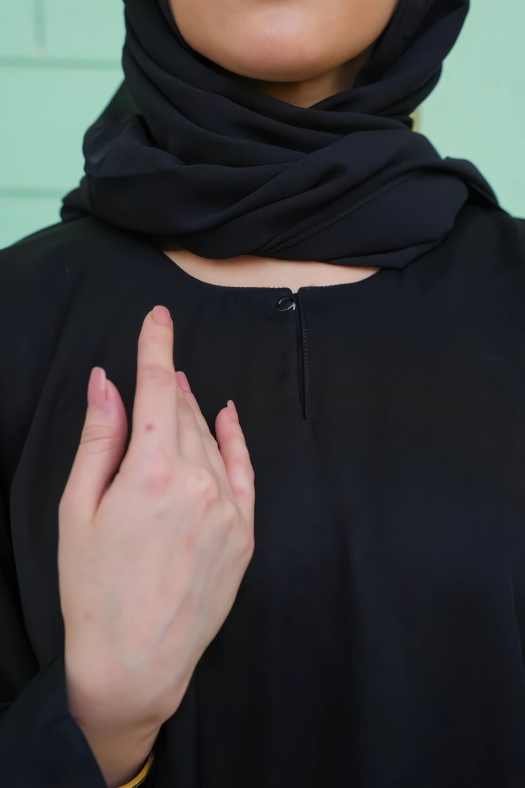 Chest zoom view of the Simple Black Abaya revealing the fine craftsmanship, soft fabric, and neat neckline finish.