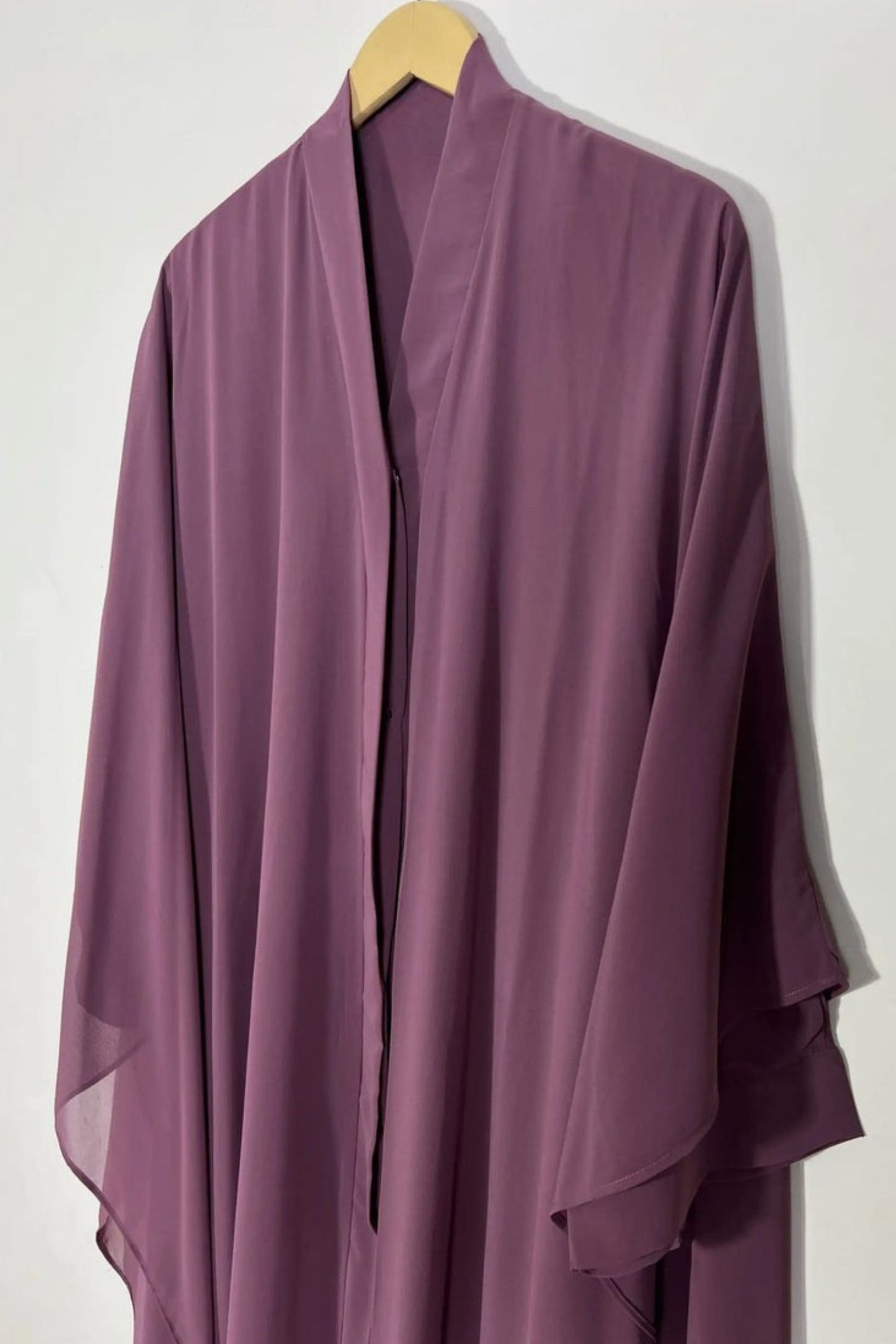 Front view of plum Halimah butterfly abaya on hanger highlighting lightweight chiffon fabric and refined finish