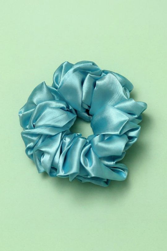Blue satin scrunchie on a light green background