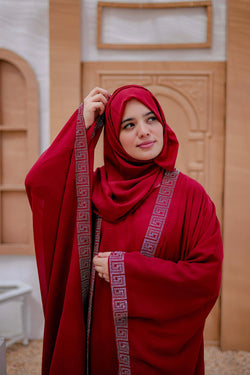 Close-up shot showing detailed embroidery and fabric texture of Arabic red kaftan abaya
