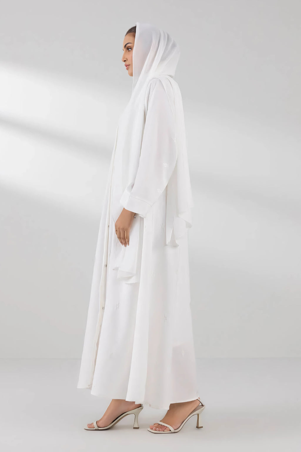 Full side angle view of white front open abaya highlighting flowy modest design