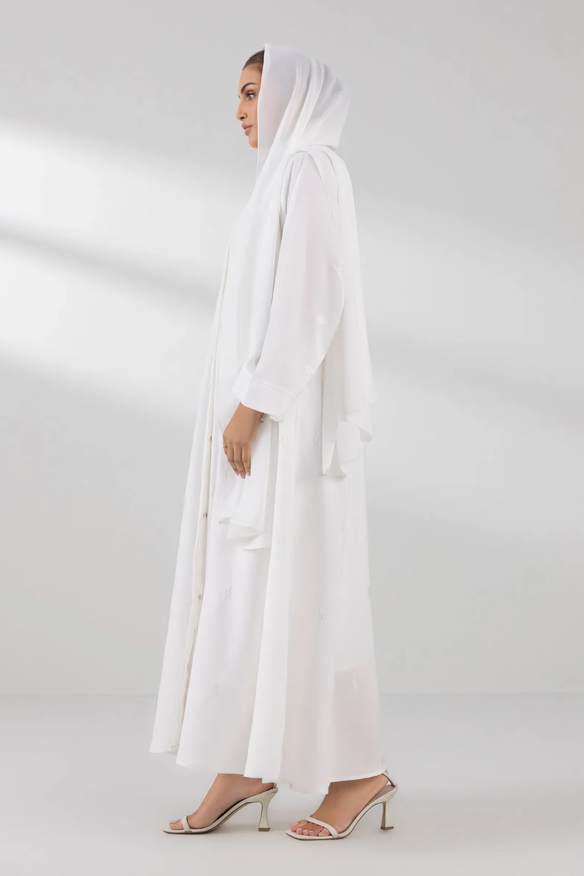 Full side angle view of white front open abaya highlighting flowy modest design