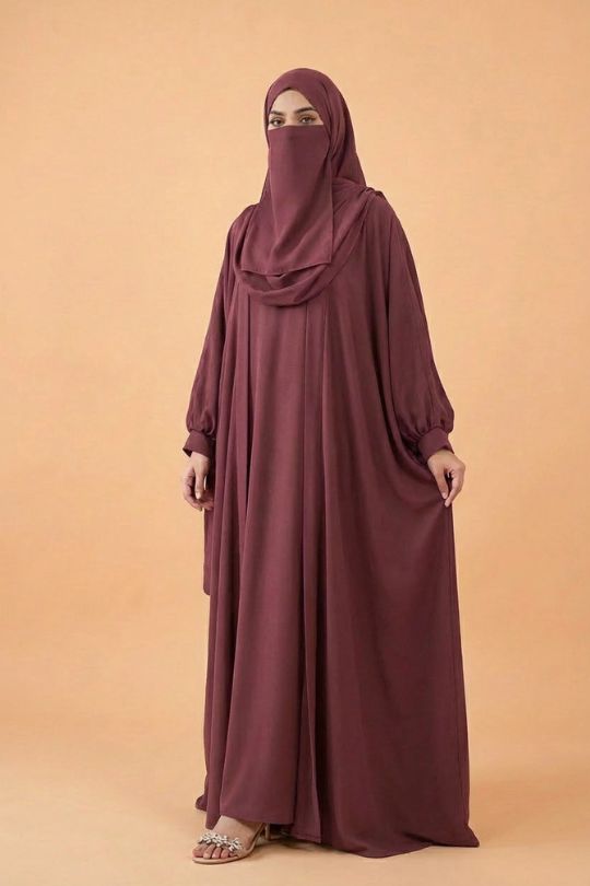 Maroon abaya worn by a model on a beige background