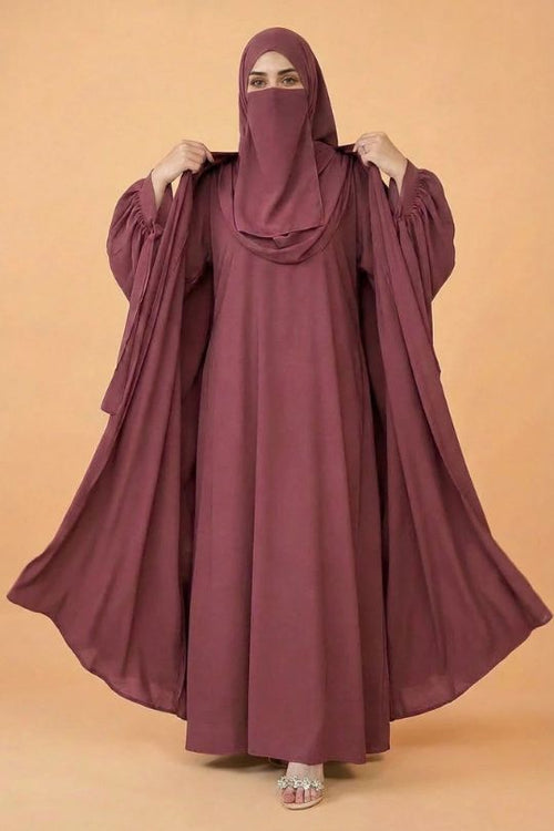Maroon abaya worn by a model on an orange background