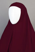 Maroon hijab on a mannequin against a gray background