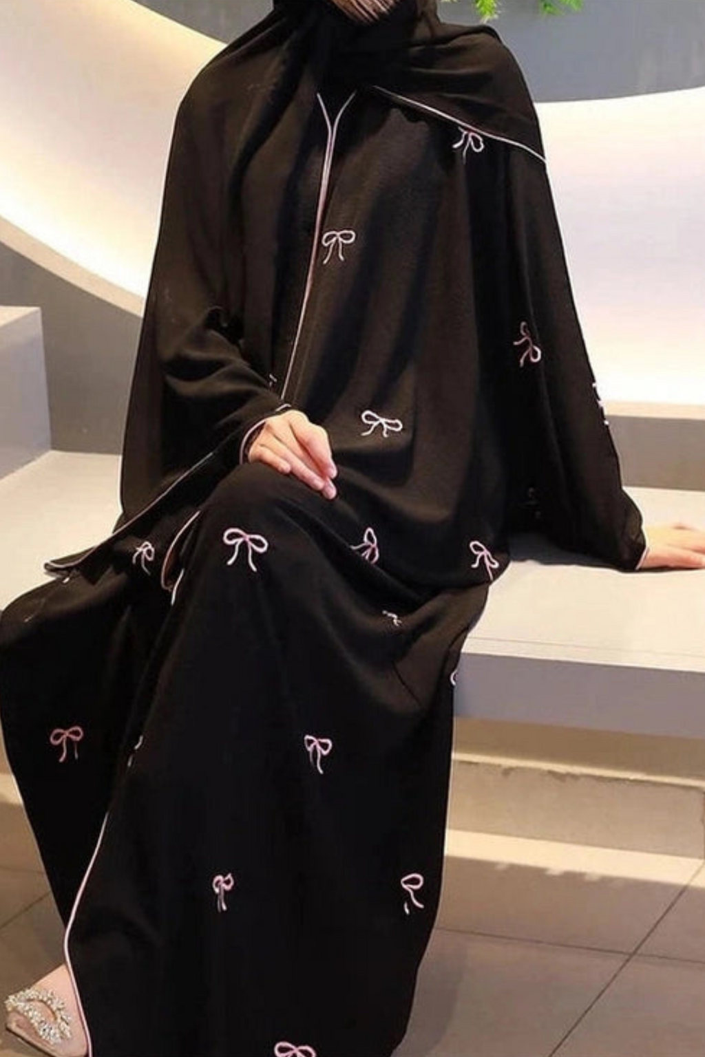 odel wearing the Luxe Bow Abaya showcasing elegant bow design, premium nida fabric, and modest full-length style for women