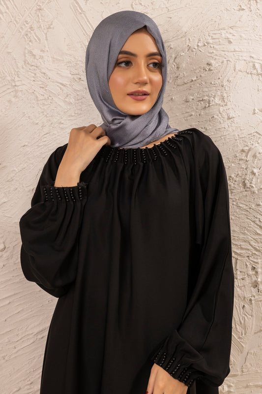 Close-up zoom showing pearl embellishment design on neckline of black abaya, stylish modest wear abaya for women in Pakistan