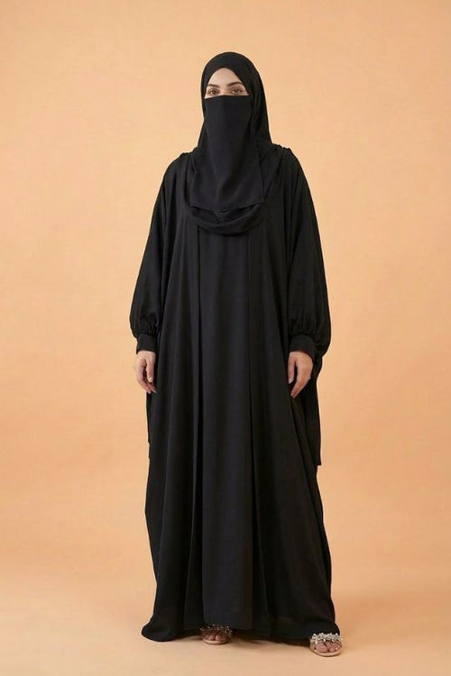 Person wearing a black abaya and hijab on a beige background