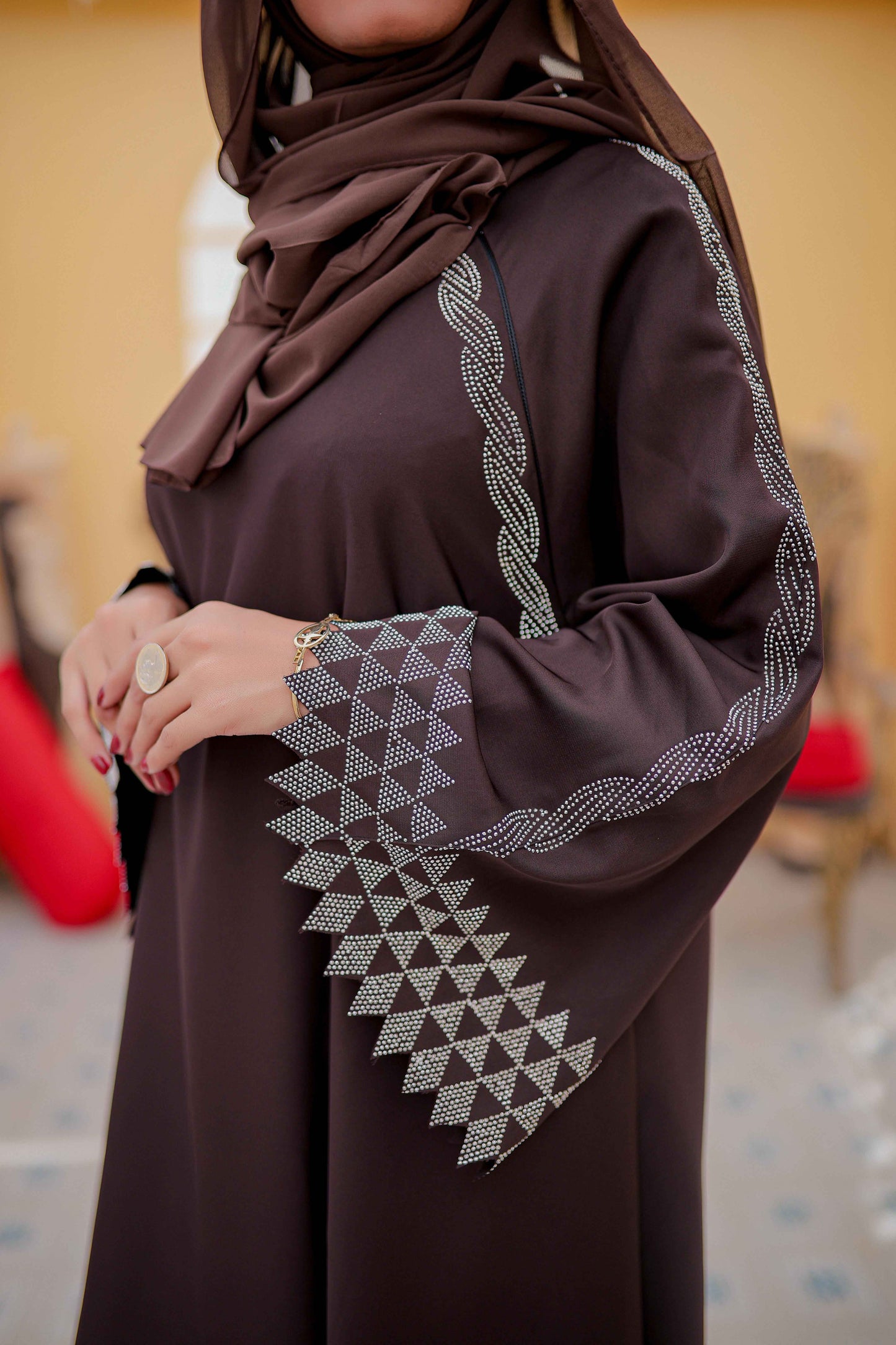 Zoomed-in side view of nug work detailing on sleeves of plain white abaya