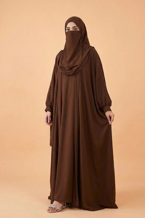 Woman wearing a brown abaya on a beige background