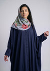 Woman wearing a floral hijab and navy blue dress against a white background