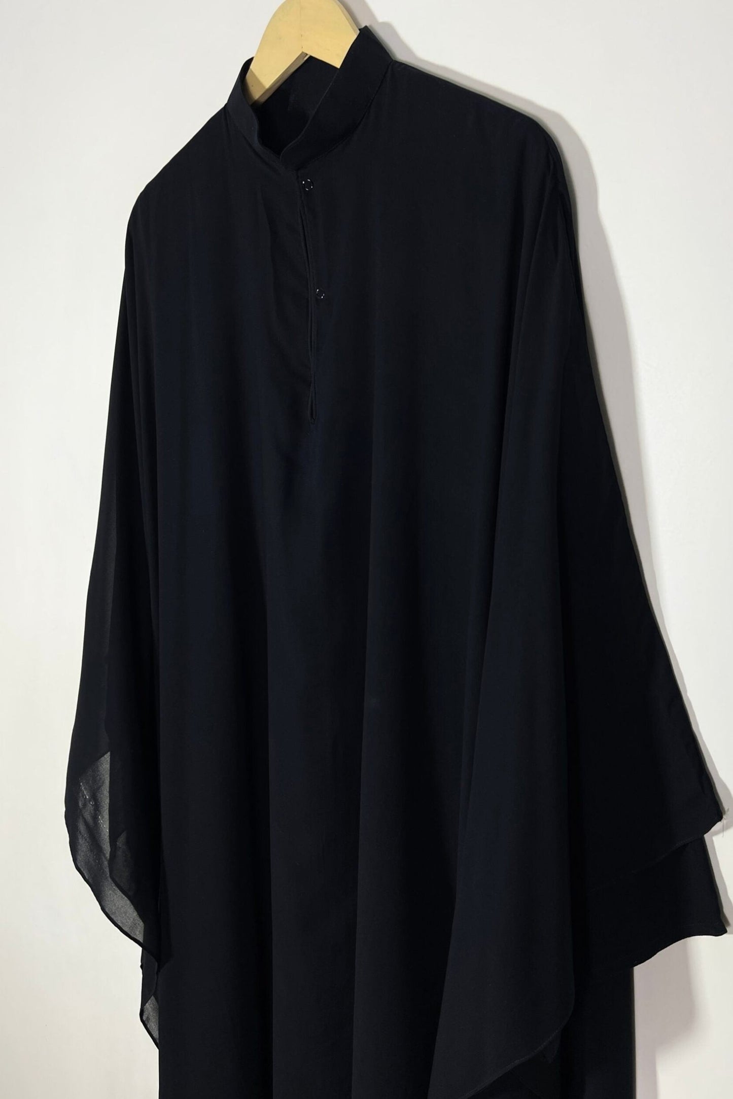 Front view of black Halimah butterfly abaya on hanger highlighting lightweight chiffon fabric and refined drape