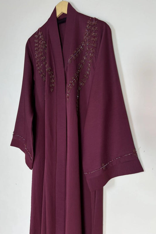 Maroon Essence of Dreams abaya hanging on hanger showing premium nida fabric and front open handcrafted design
