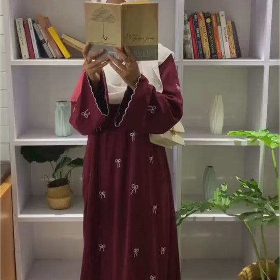 Video of Red Bow Embroidered Zoom Nida Abaya in red, displaying front, side, and back angles with detailed embroidery and elegant flow.