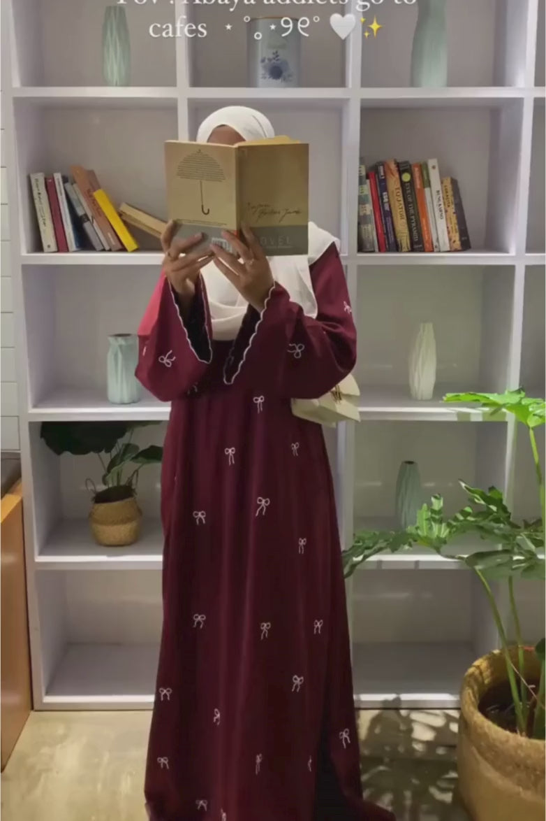 Video of Red Bow Embroidered Zoom Nida Abaya in red, displaying front, side, and back angles with detailed embroidery and elegant flow.